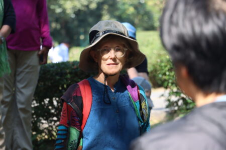 Participant in a colorful jacket and hat during a walk at Ang Kaew Reservoir.