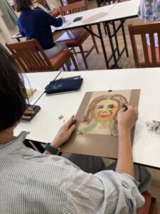 Participant Creating a Portrait with Oil Pastels.