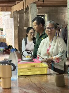 Participants of the Chiang Rai excursion engage with local community members in a warm and casual setting. The image captures an interaction between a local community leader and the visitors, highlighting the ongoing cultural exchange and mutual respect that forms the core of this educational journey.