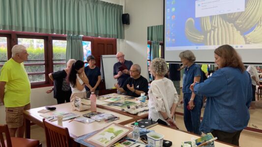 Richie Cheung demonstrates watercolor techniques to students during class discussion.