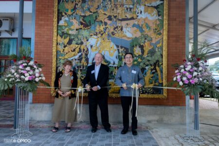 Nicole Simmons, Ambassador Eric Rubin, and President Apicha Insuwan participate in a ribbon-cutting ceremony to officially dedicate the large carved wooden mural.