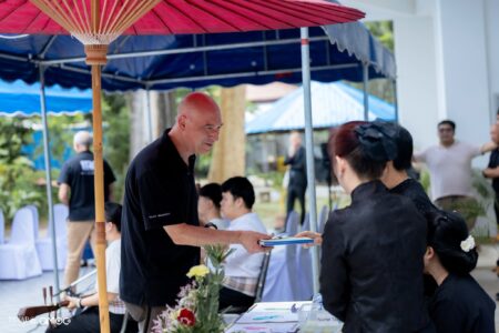 A guest receives an event program or book while checking in at the registration desk for the Mural Dedication Ceremony.