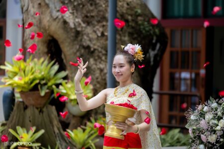 Traditional blessing dancer Mymint scatters flower petals during the dedication ceremony, welcoming guests with a Lanna cultural performance.