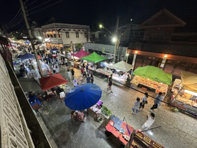 A lively evening view from Ajarn Viti's balcony overlooking the colorful Kad Kong Ta walking street.