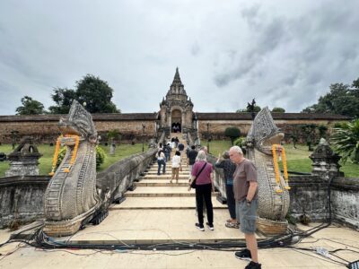 Visitors ascend the grand Naga staircase at Wat Phra That Lampang Luang, experiencing Lampang's historic spiritual culture.